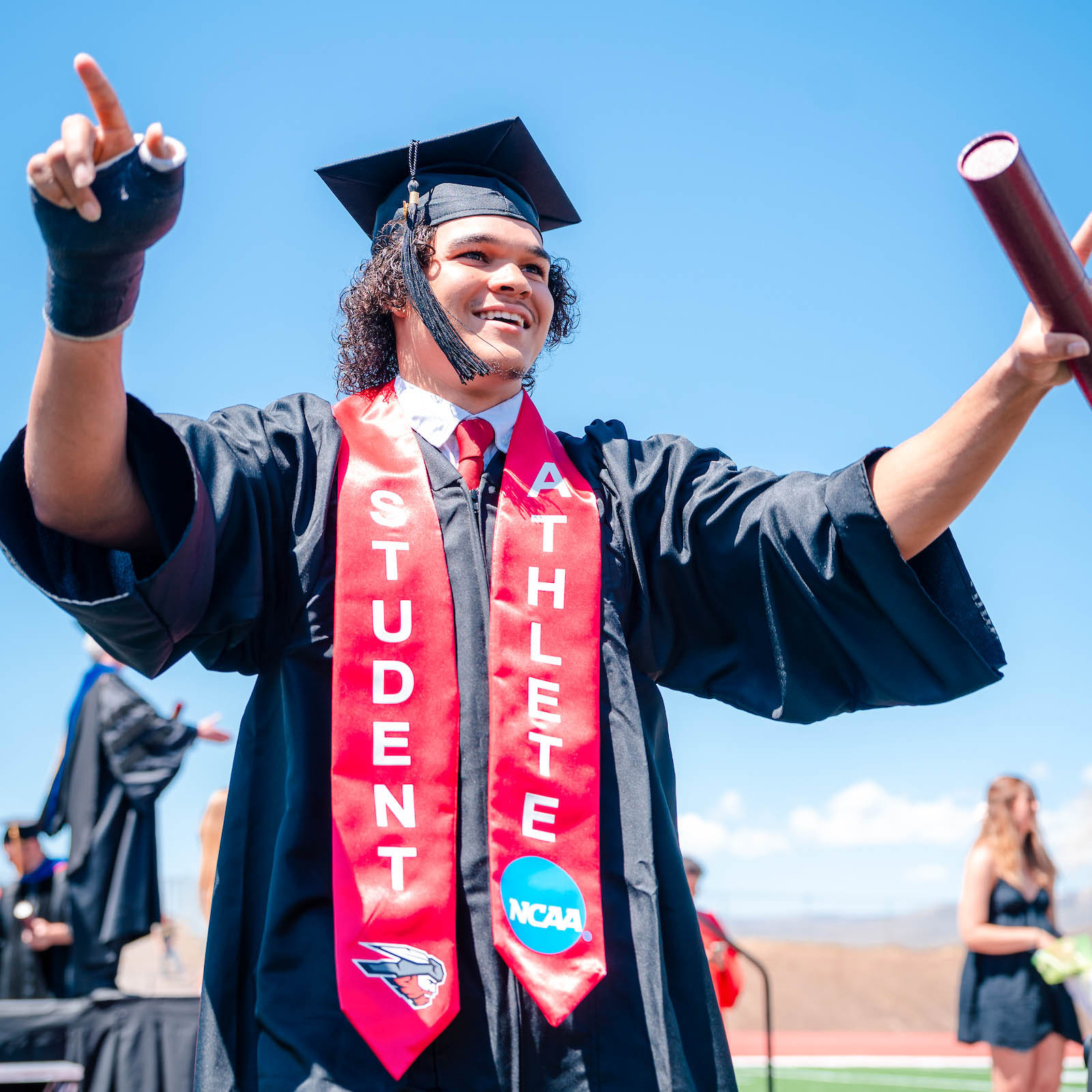 A graduate celebrates after receiving his diploma.