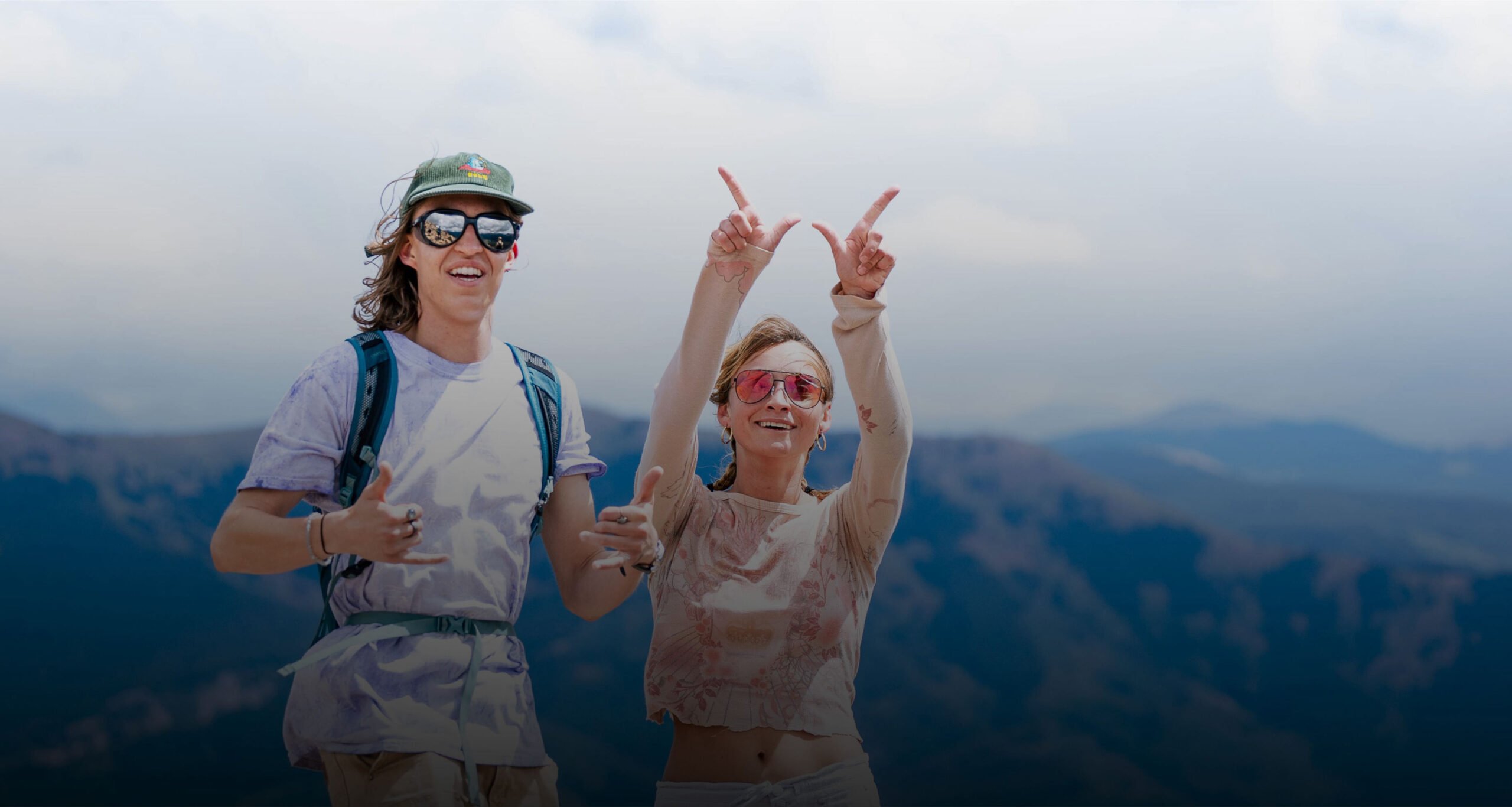 2 students pose while hiking to the summit of Mt. Crested Butte during university day.