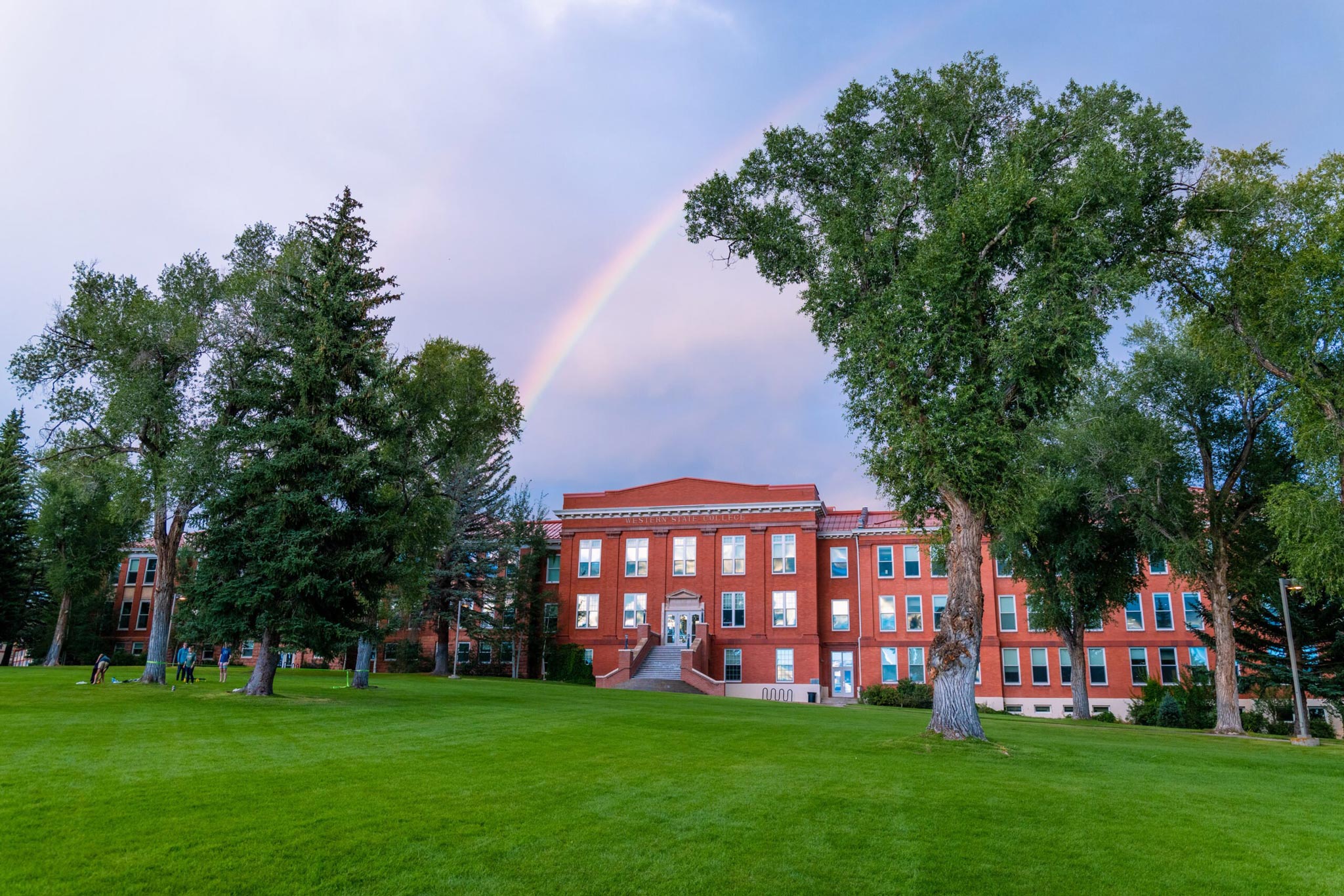 A photo of a rainbow seen above Taylor Hall at sunset.