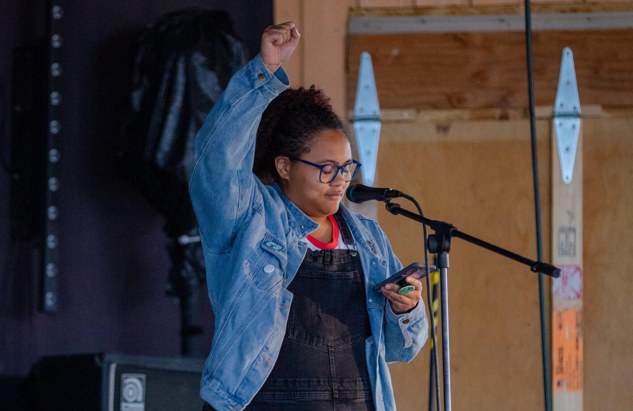 A graduate student reads a piece of literature aloud into a microphone during a summer residency on campus.