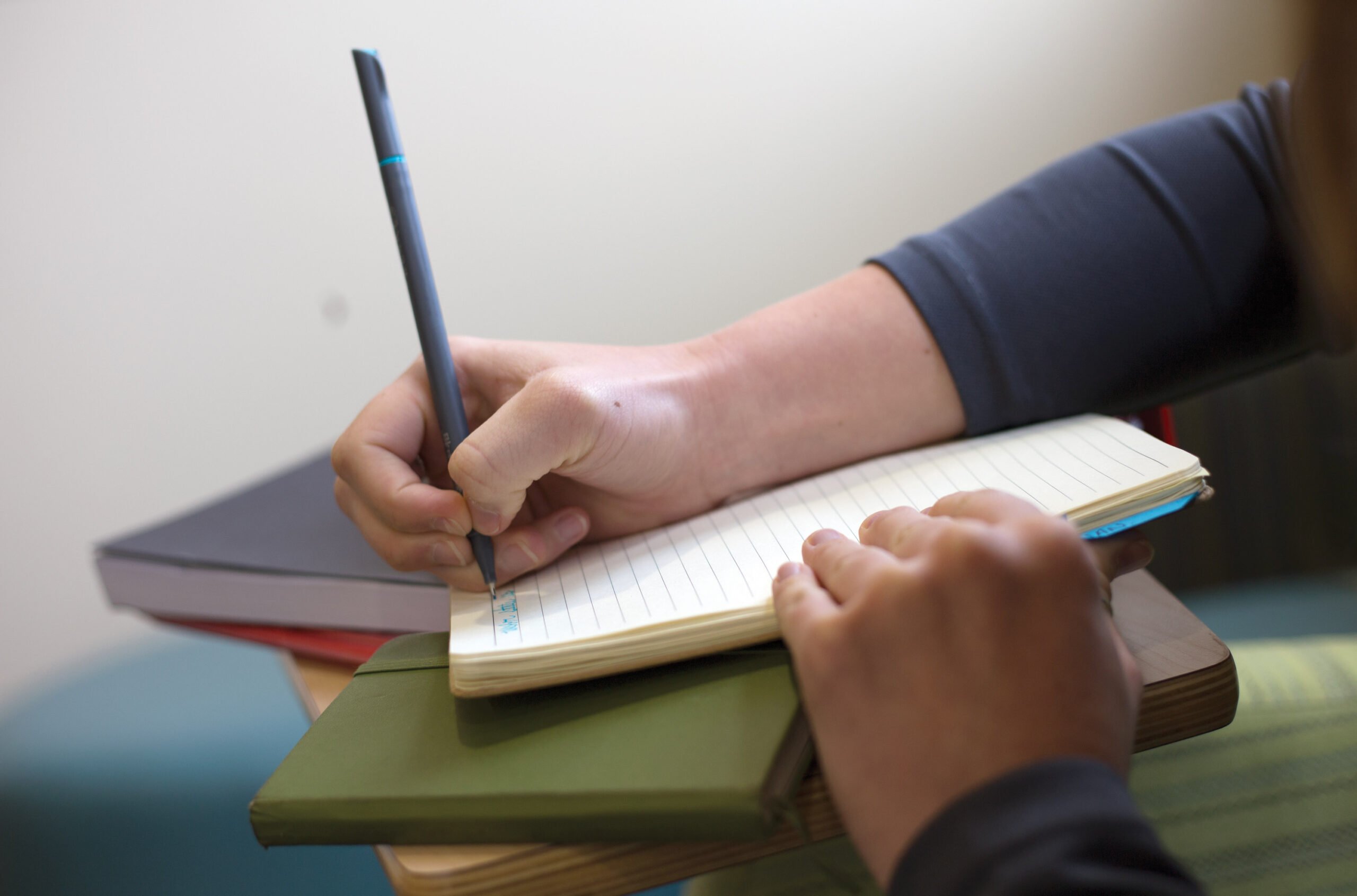 A person writing in a notebook