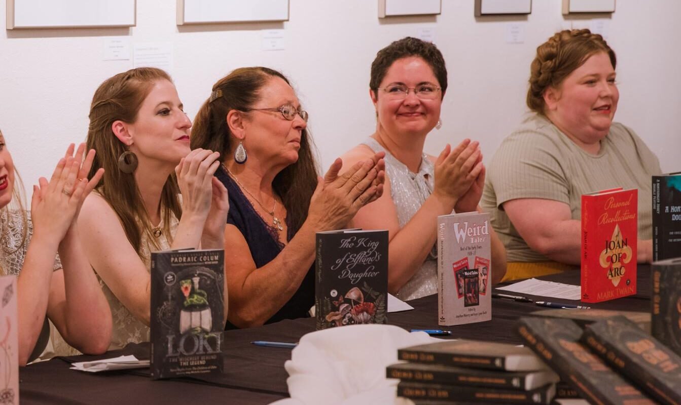 Four Publishing students it behind their books at a signing event for the Graduate Program in Creative Writing.