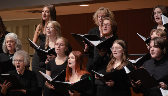 A close up of the chamber choir performing on stage